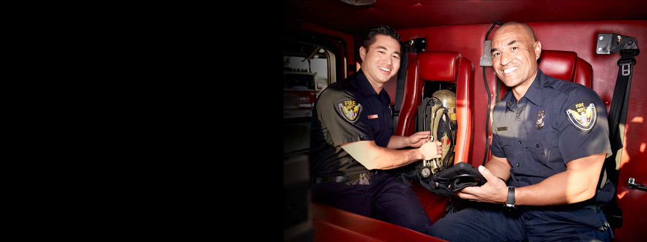 Two firefighters smiling at the camera