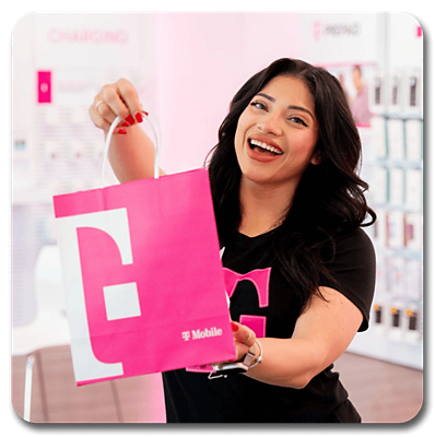 A T-Mobile employee handing out a T-Mobile bag in a T-Mobile store.