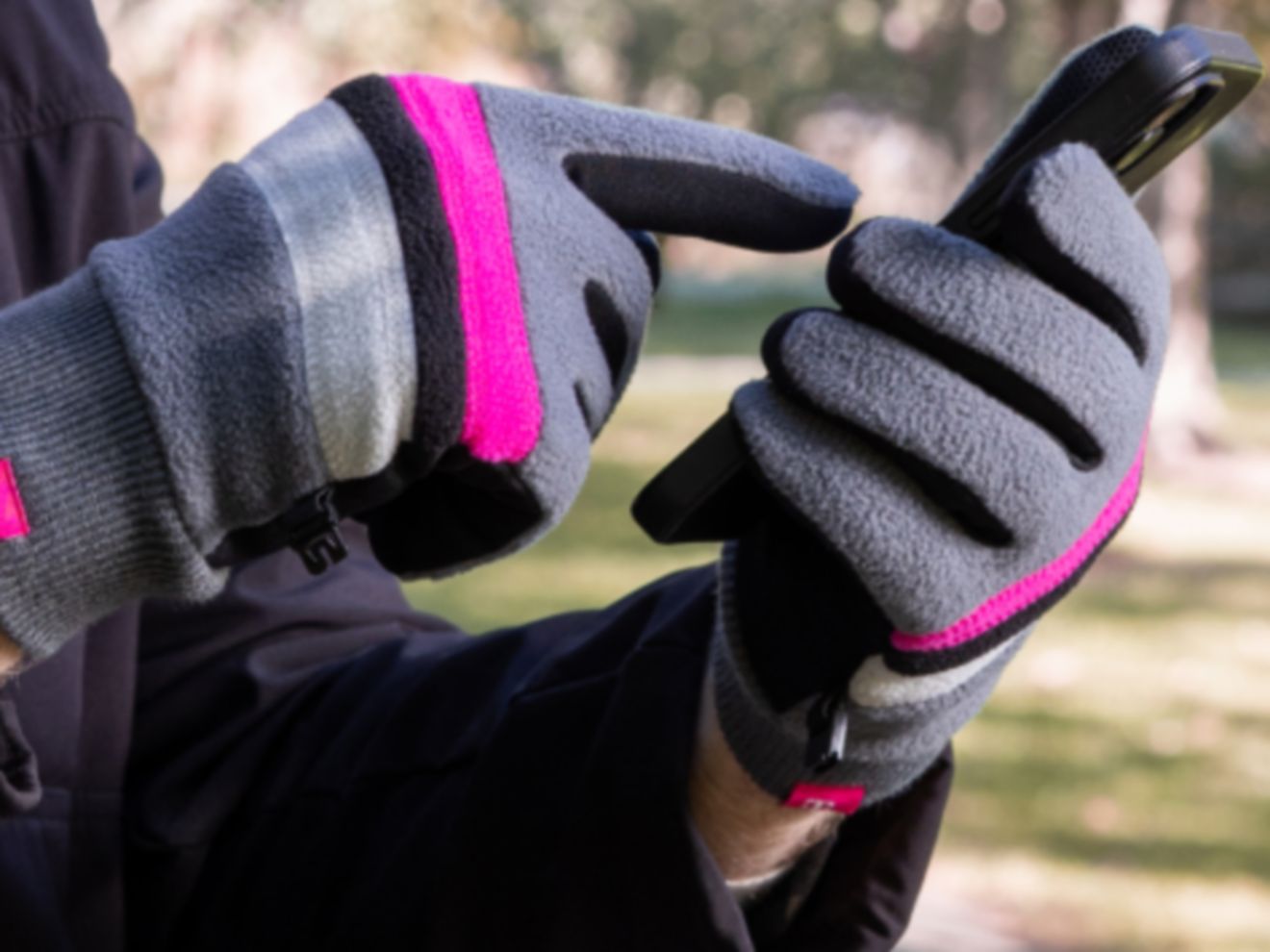 Person using touchscreen gloves to scroll through their phone.