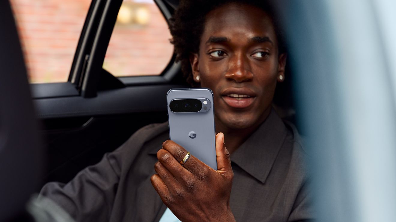 Person in a car holding a Google Pixel 10 Pro.
