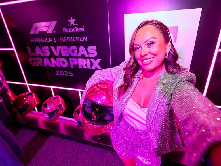 An F1 fan posing with a racing helmet and smiling. 