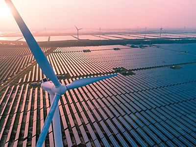 Aerial view of wind and solar power generation farm at sunset.