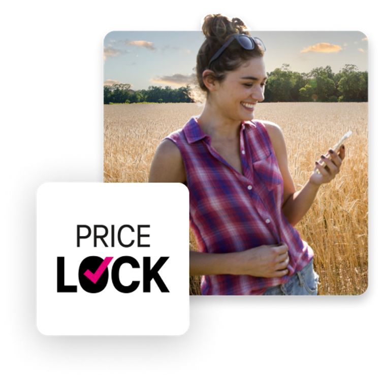 Lady in a wheat field looking at her phone, laughing.