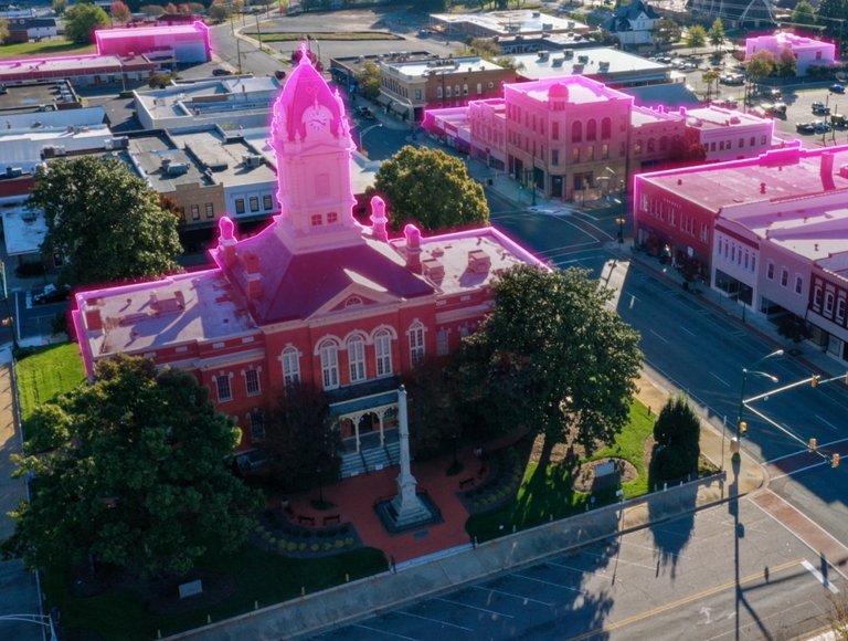 Aerial view of a small town that’s glowing Magenta