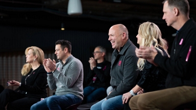 Group of T-Mobile Senior Leadership Team members applauding.