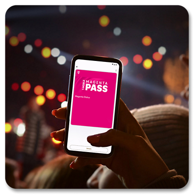 A woman at a concert holds up her phone displaying a Magenta Pass.