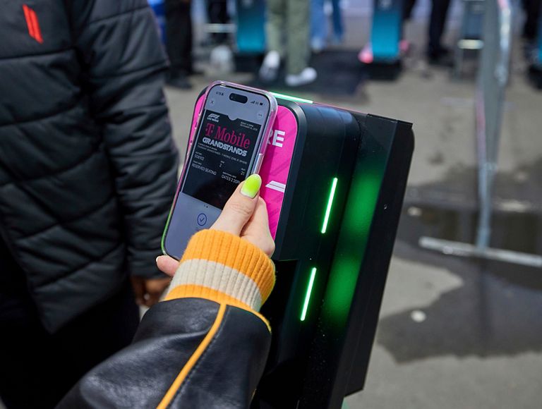 Someone tapping their phone against a ticket reader. 