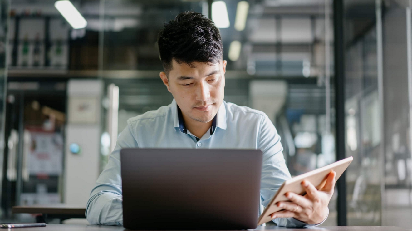 A government professional works on a connected laptop.