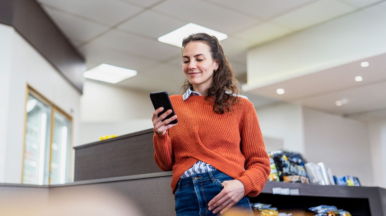 A retail employee on a break uses their smartphone to check inventory.