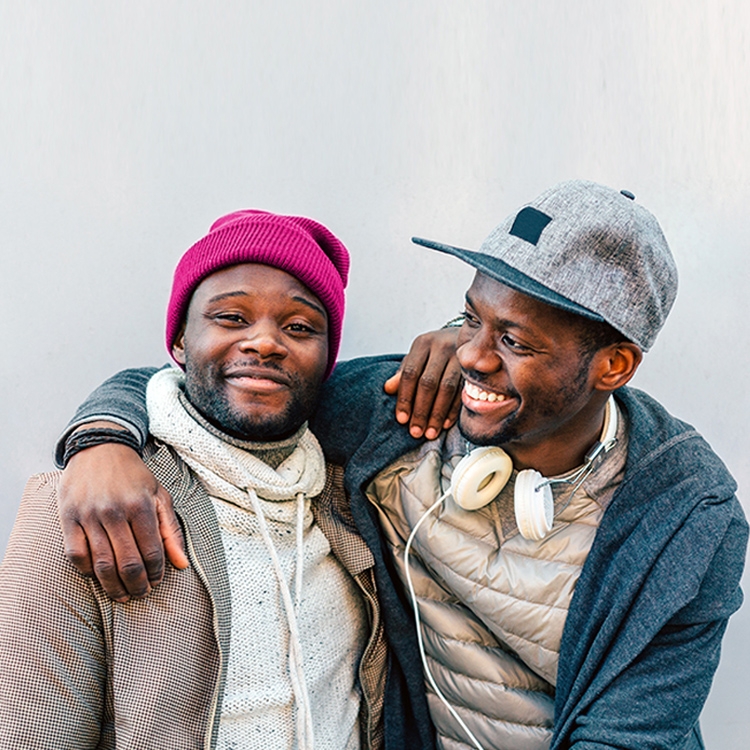 Two men embracing and smiling.