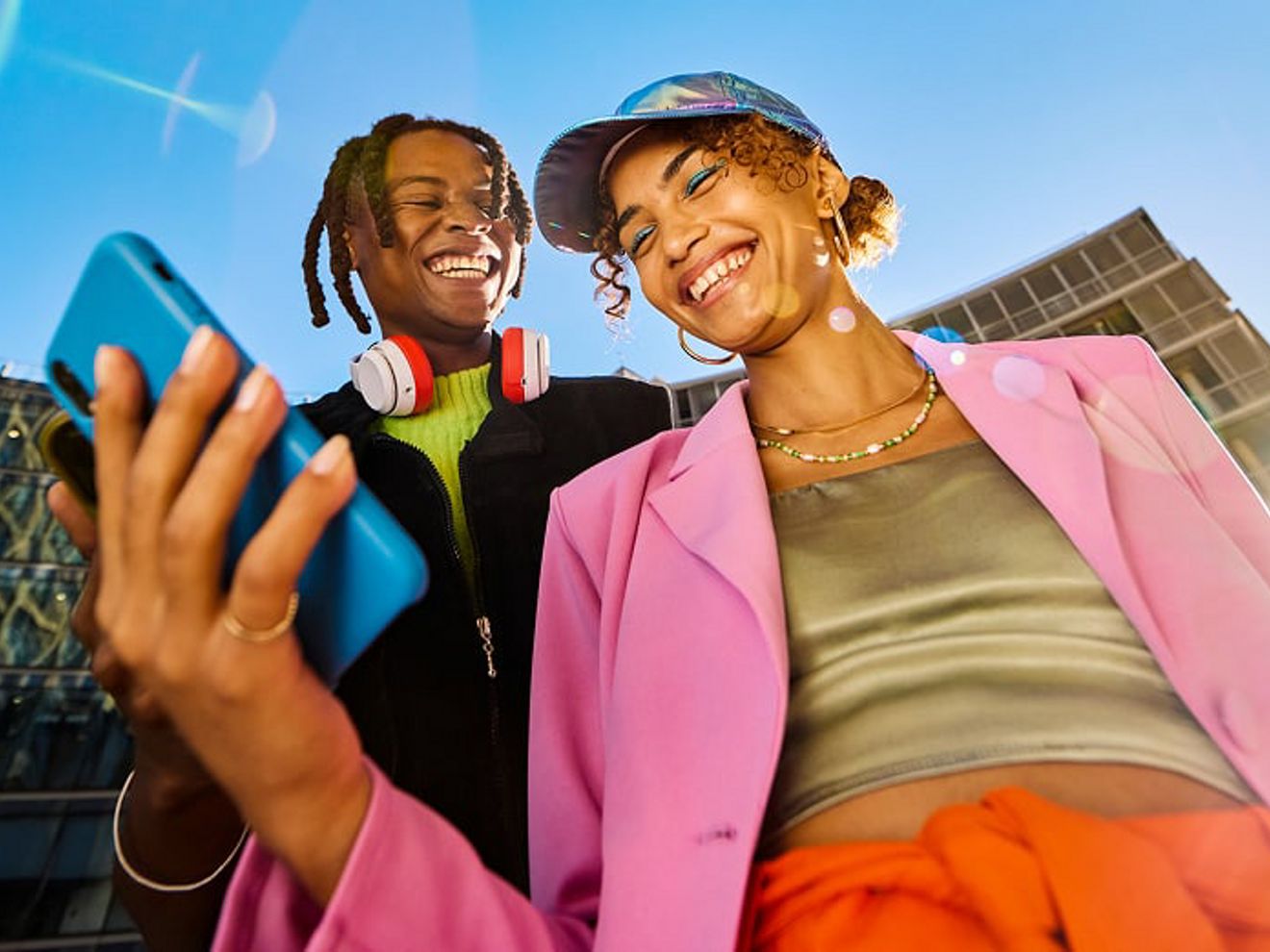 A couple looking at their phones and smiling.