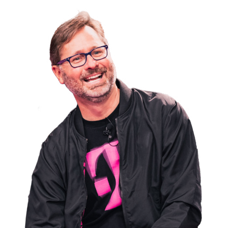 CEO Mike Sievert smiling and wearing a black jacket over a shirt with the Magenta T on it.