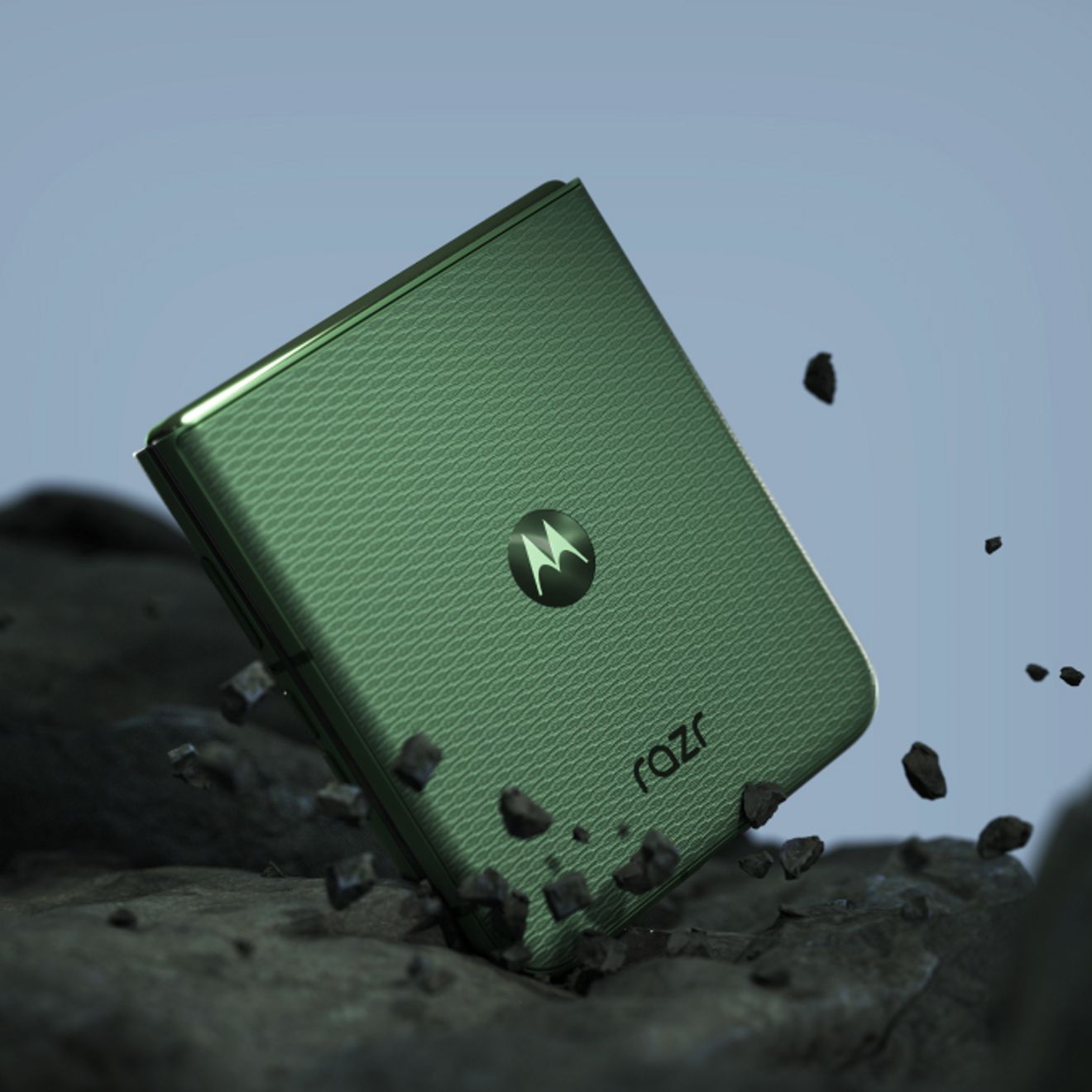 motorola razr in PANTONE® Mountain View standing partially folded on rocky terrain, highlighting its durable flip design.