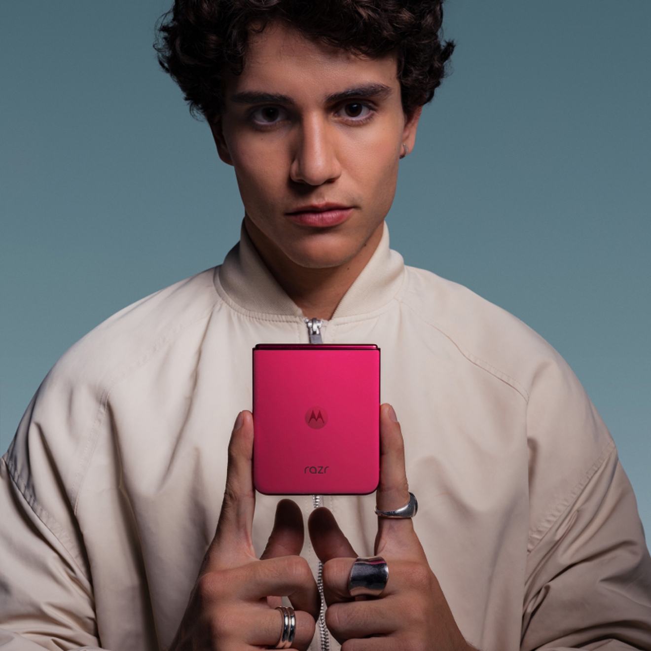 Young person demonstrating how compact his Motorola razr plus is by holding it with just two fingers.