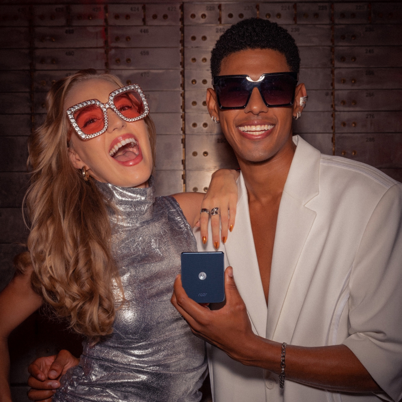 Couple taking fun selfies with motorola razr at a party.