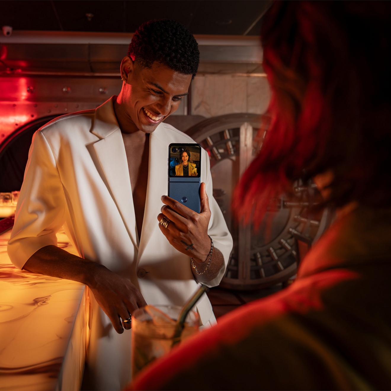 Person holding up a Motorola razr to share a photo of a friend on the exterior screen.