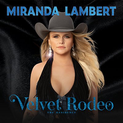 Miranda Lambert stares into the camera, wearing a cowboy hat, fringe top, and sparkling earrings.