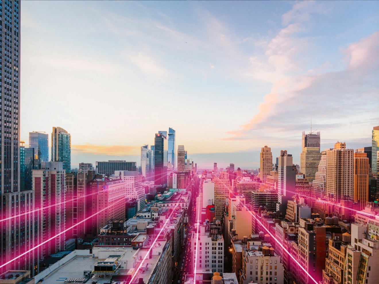A cityscape at sunrise, illuminated by magenta beams. 