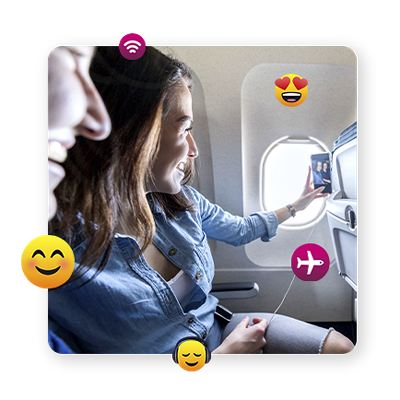Una pasajera sonríe para una selfie con una amiga en el avión.