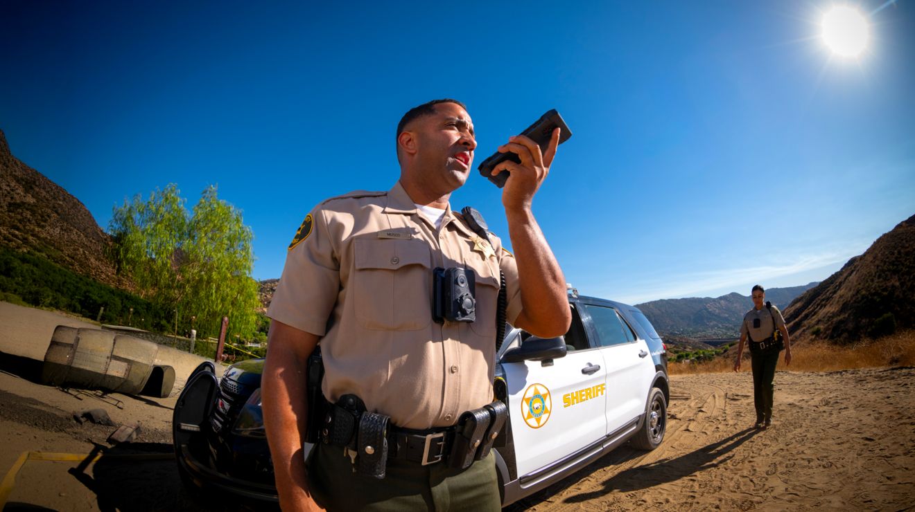 A sheriff's deputy connects over a secure smartphone from an incident scene at a rural location.