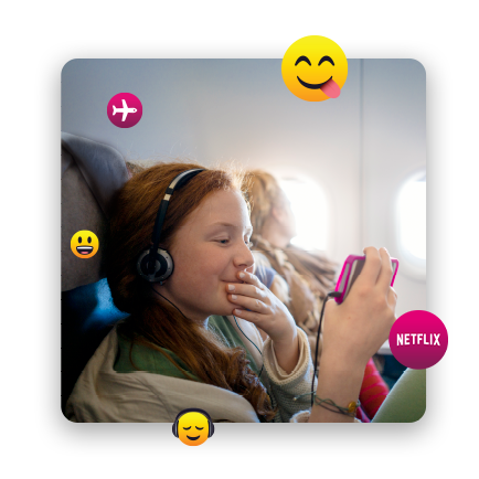 Young girl on a plane with headphones on watching something on her phone 