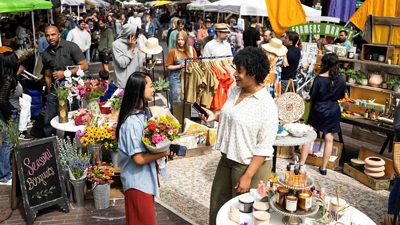 A pop-up entrepreneur sells a customer a bouquet of flowers.