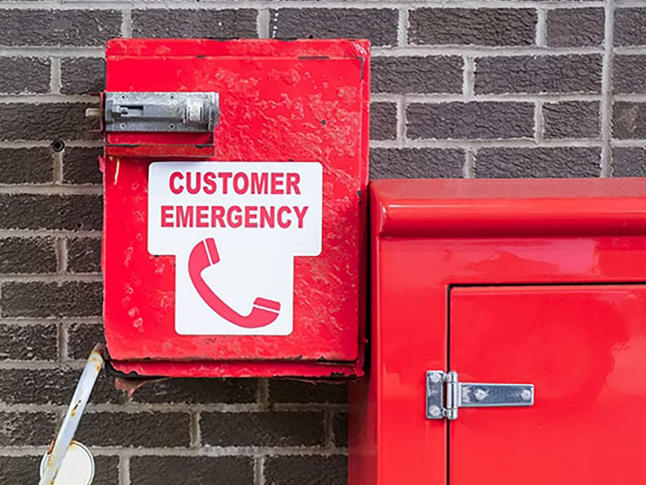 Red emergency phone boxes attached to a building.