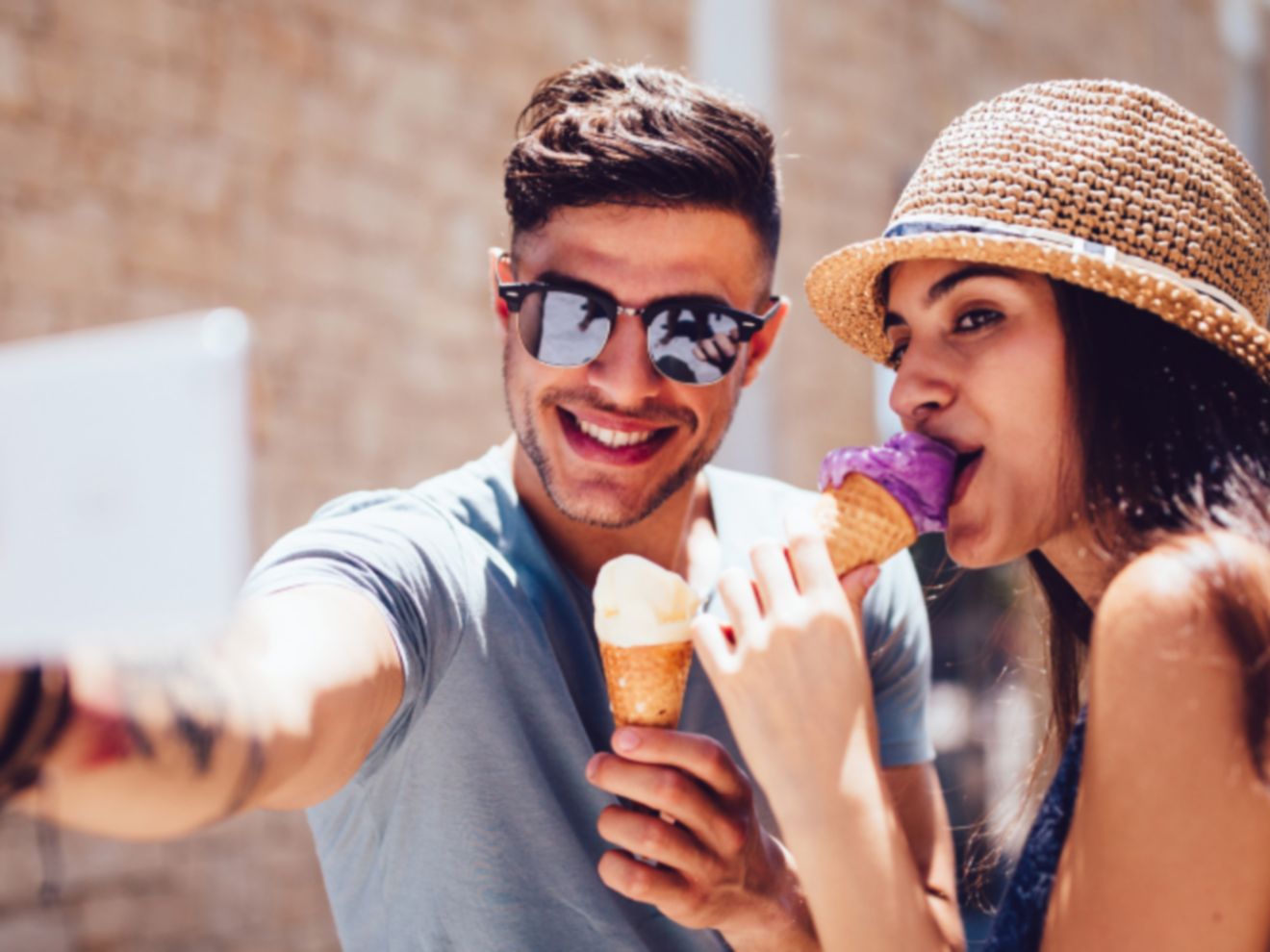 A man and woman taking a selfie with a smartphone