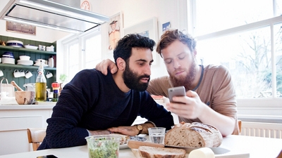 Couple looking at phone over dinner.