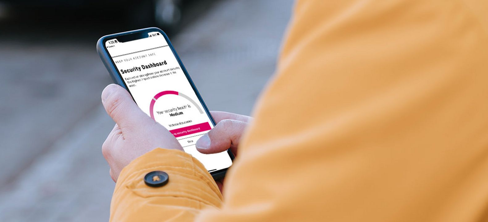 Person holds phone with Security Dashboard open.