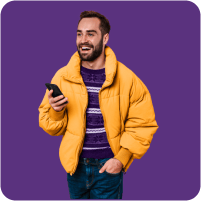 Man in a puffy jacket laughing about something on his smartphone.