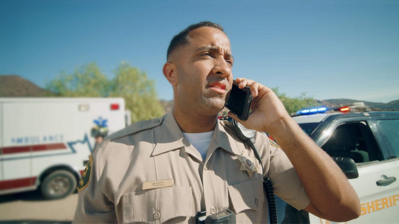 Sherrif on the phone outside his vehicle