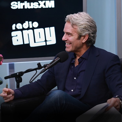 A man in a podcast studio speaking into a microphone.