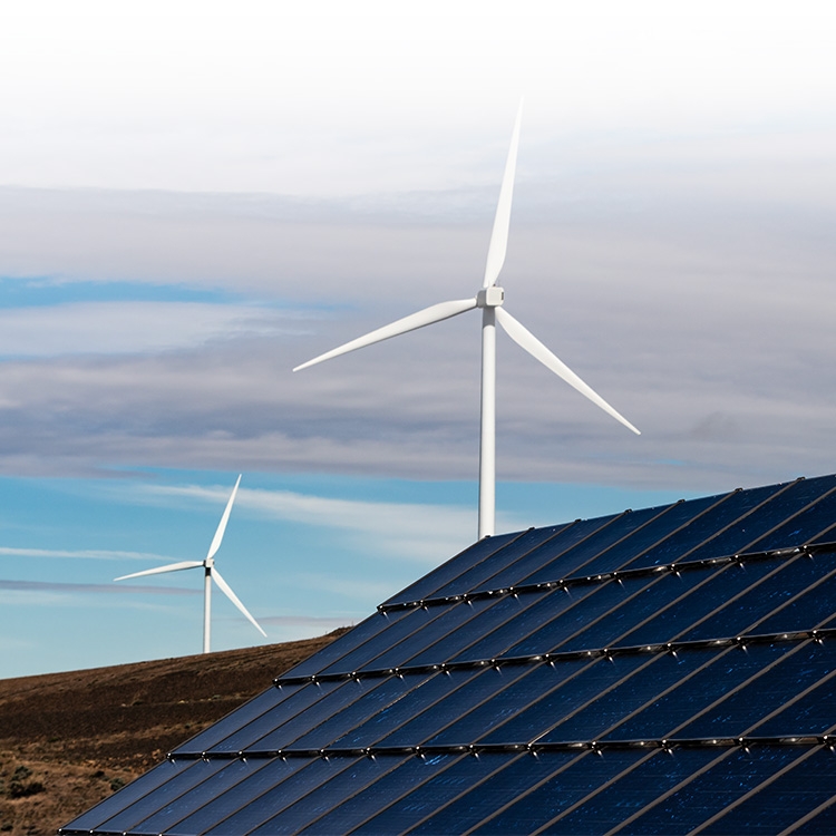 Two wind turbines behind solar panels
