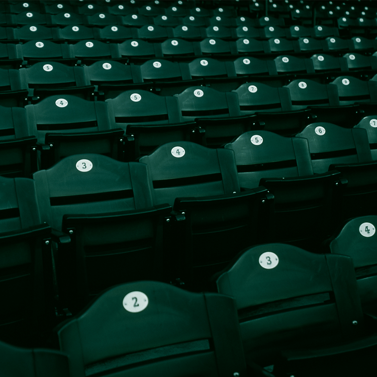 Green chairs of a stadium as a background.