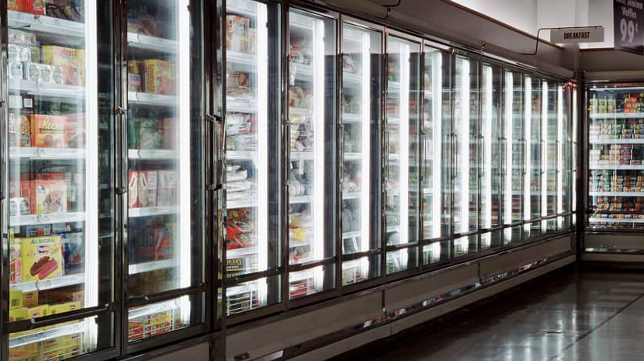 Sensor-equipped display cases line the frozen food aisle of a supermarket.