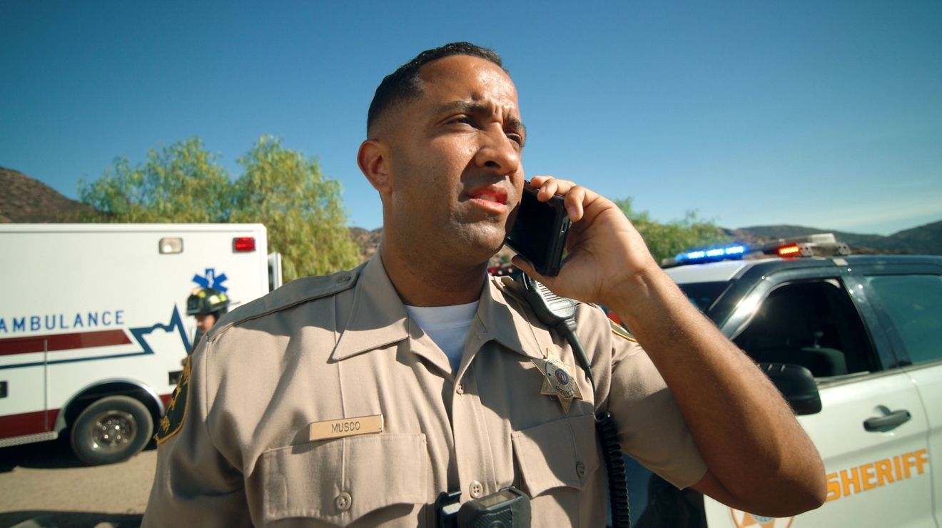 A police officer in a car uses a monitor and keyboard to transmit mission-critical updates.