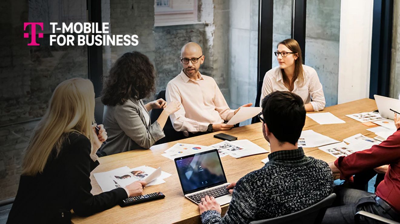 T-Mobile for Business. A group of people sit around a conference table.