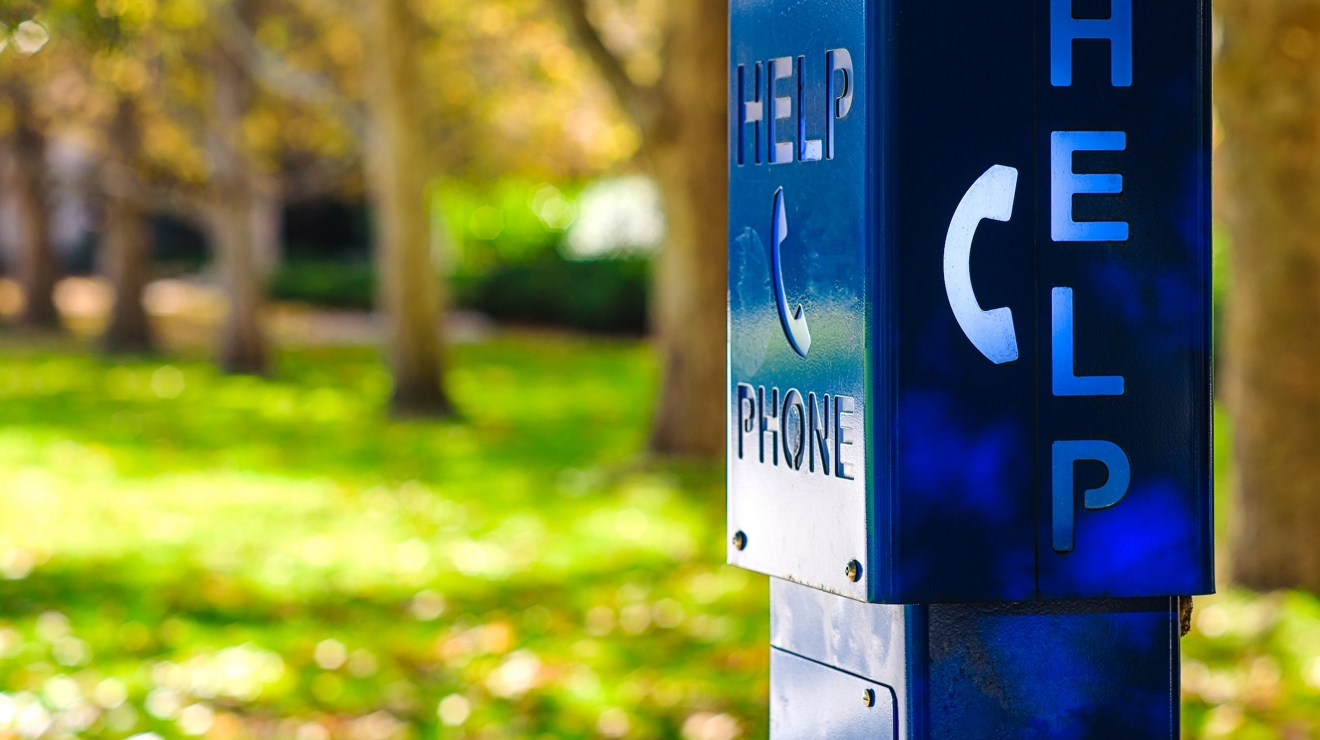 A blue emergency phone box labled "HELP" at a university campus in Melbourne, Austalia.