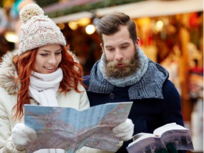 Una pareja mirando un mapa en un mercado navideño.