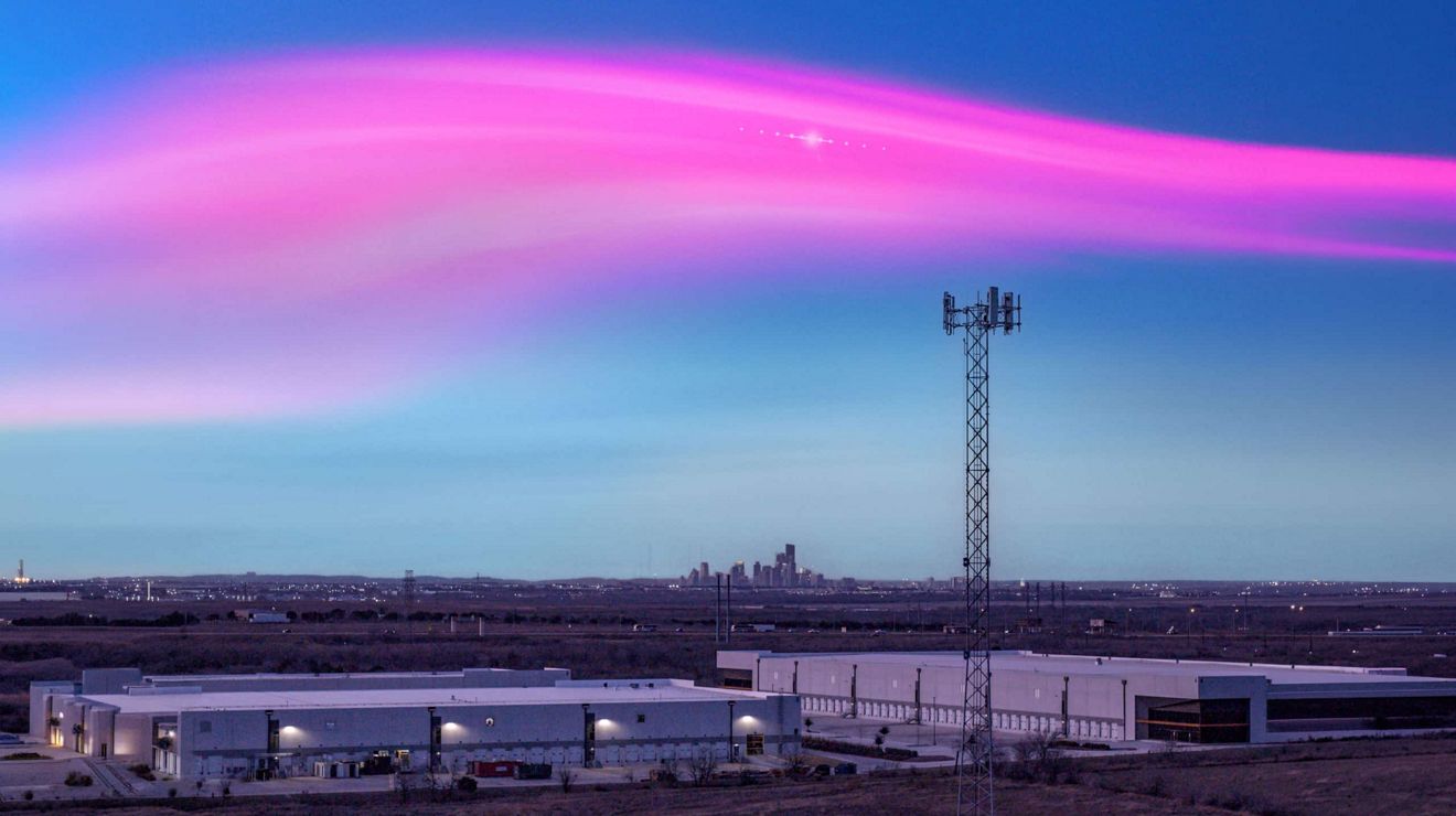 Lights from a Starlink satellite shine in the evening sky above a T-Mobile 5G cell tower.