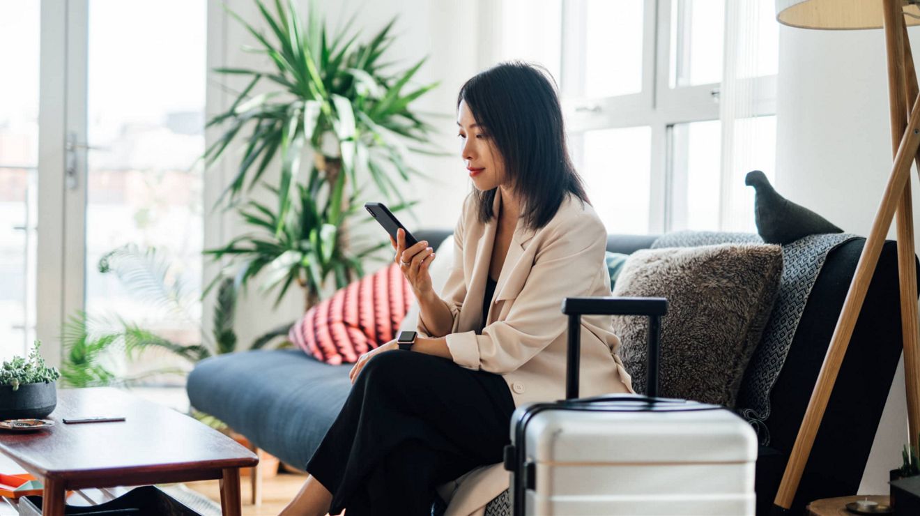 A traveler uses a T-Mobile smartphone to book discounted rental car and hotel accommodations.