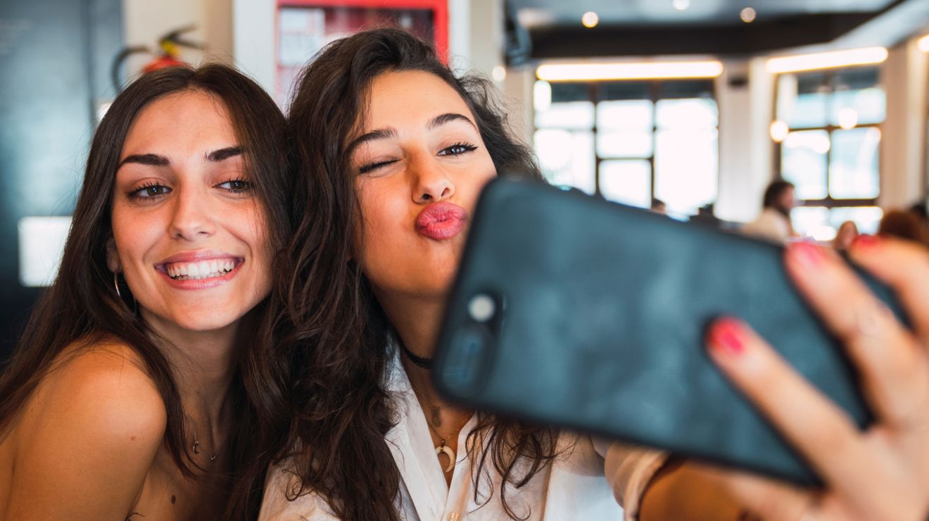 Two women smiling and taking a selfie together.