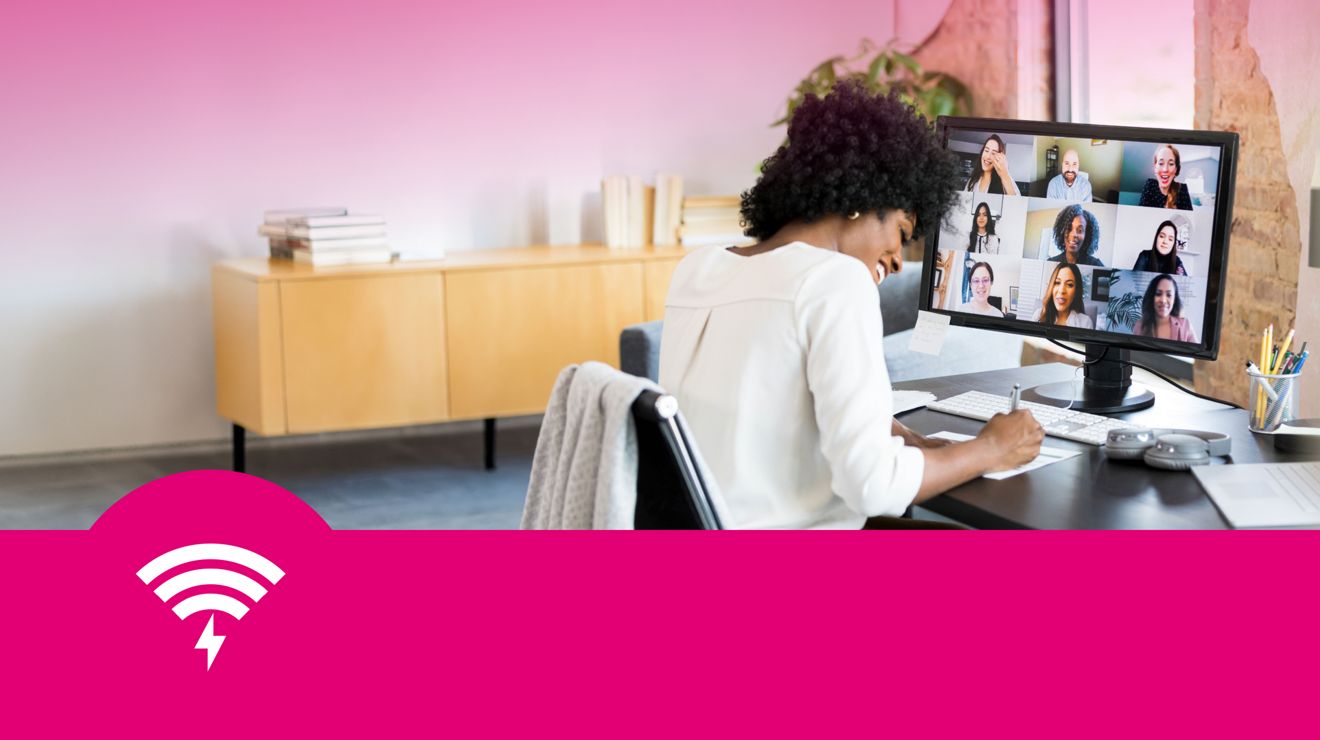 A business professional at their desk engages with multiple colleagues on a video conference.