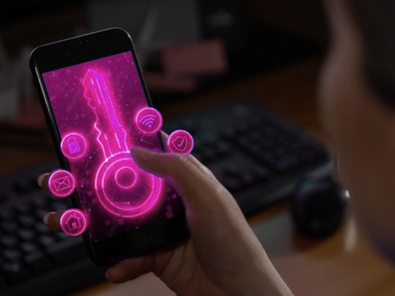 A phone screen glows with magenta animation.​ 