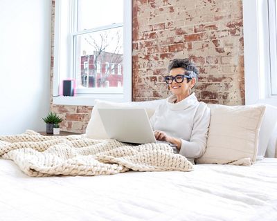 A woman in bed on a laptop.
