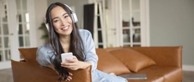 Woman smiling while she listens to music on her phone.