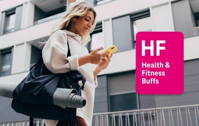 Woman with yoga bag, walking and using yellow phone outside of building.