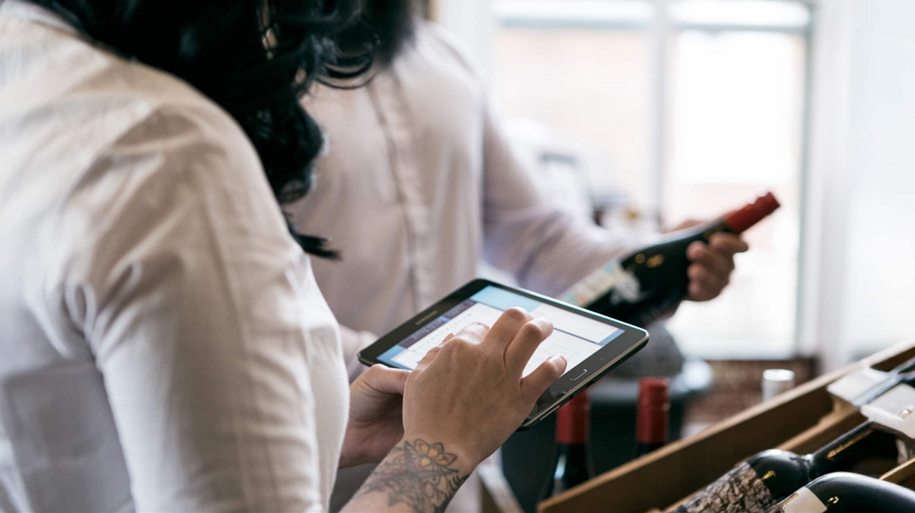 Two federal employees compare notes on connected tablets.