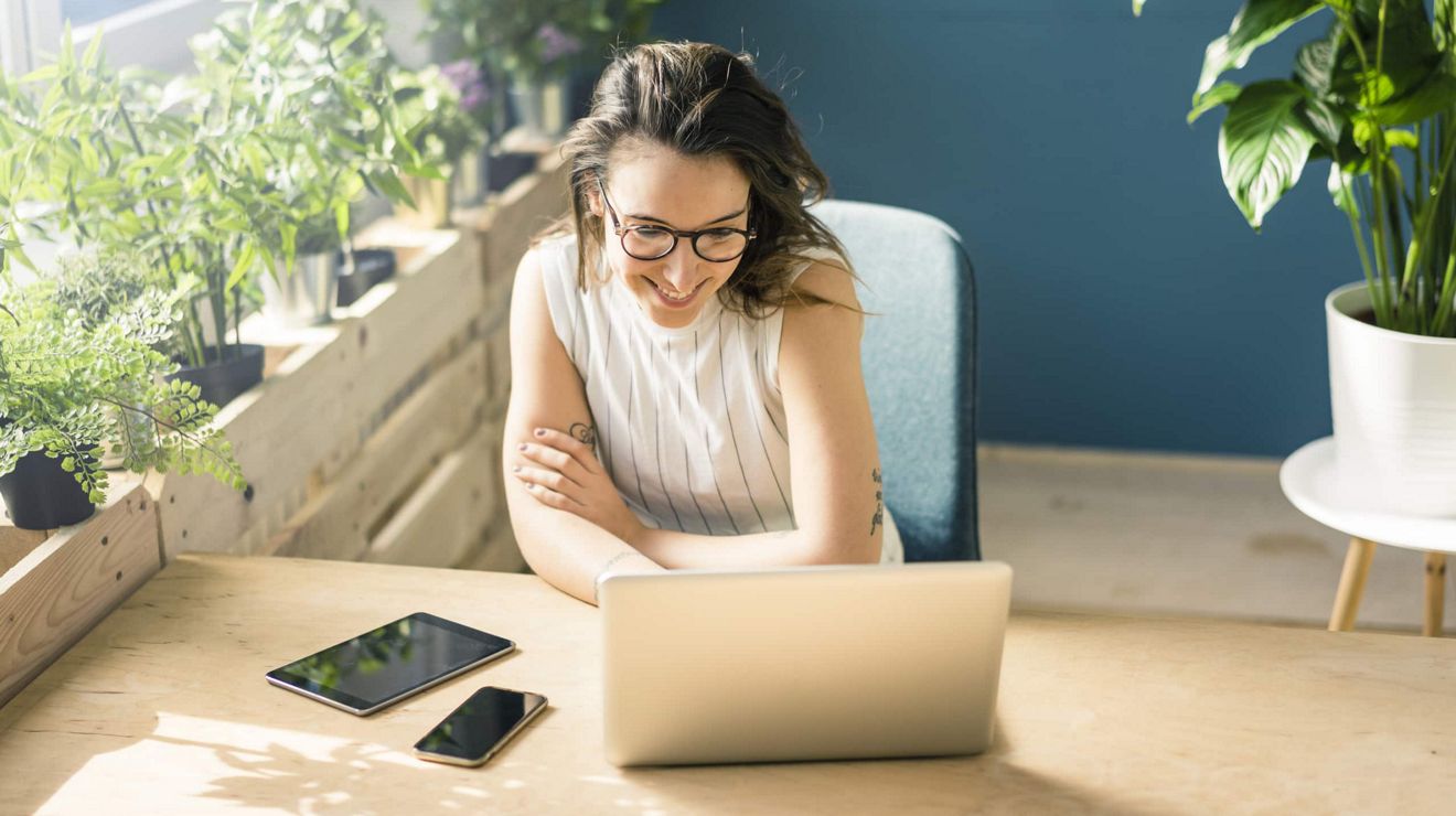 A manager accesses T-Platform on a laptop from a sunny office. 